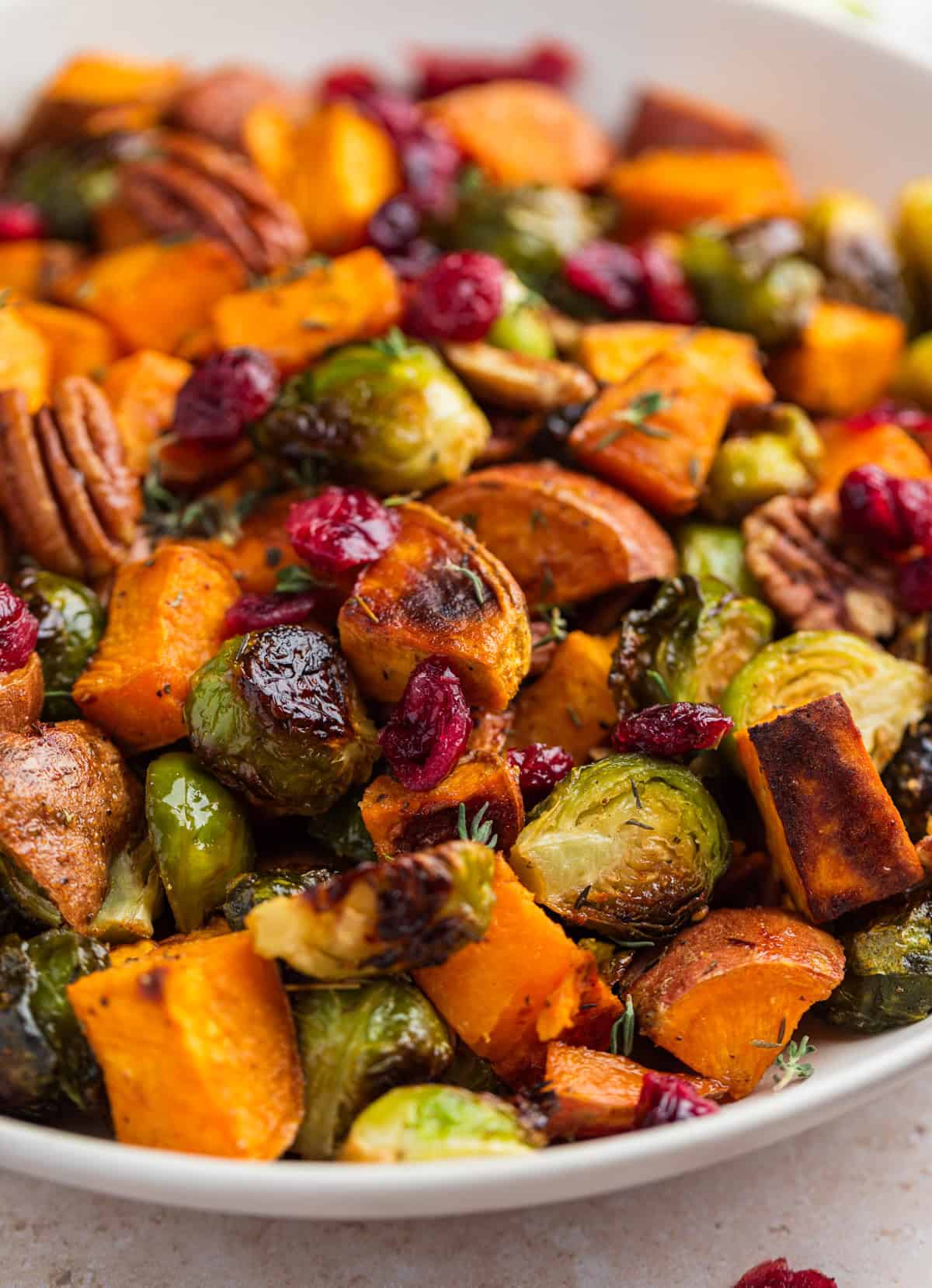 Serving dish with roasted vegetables and pecans.