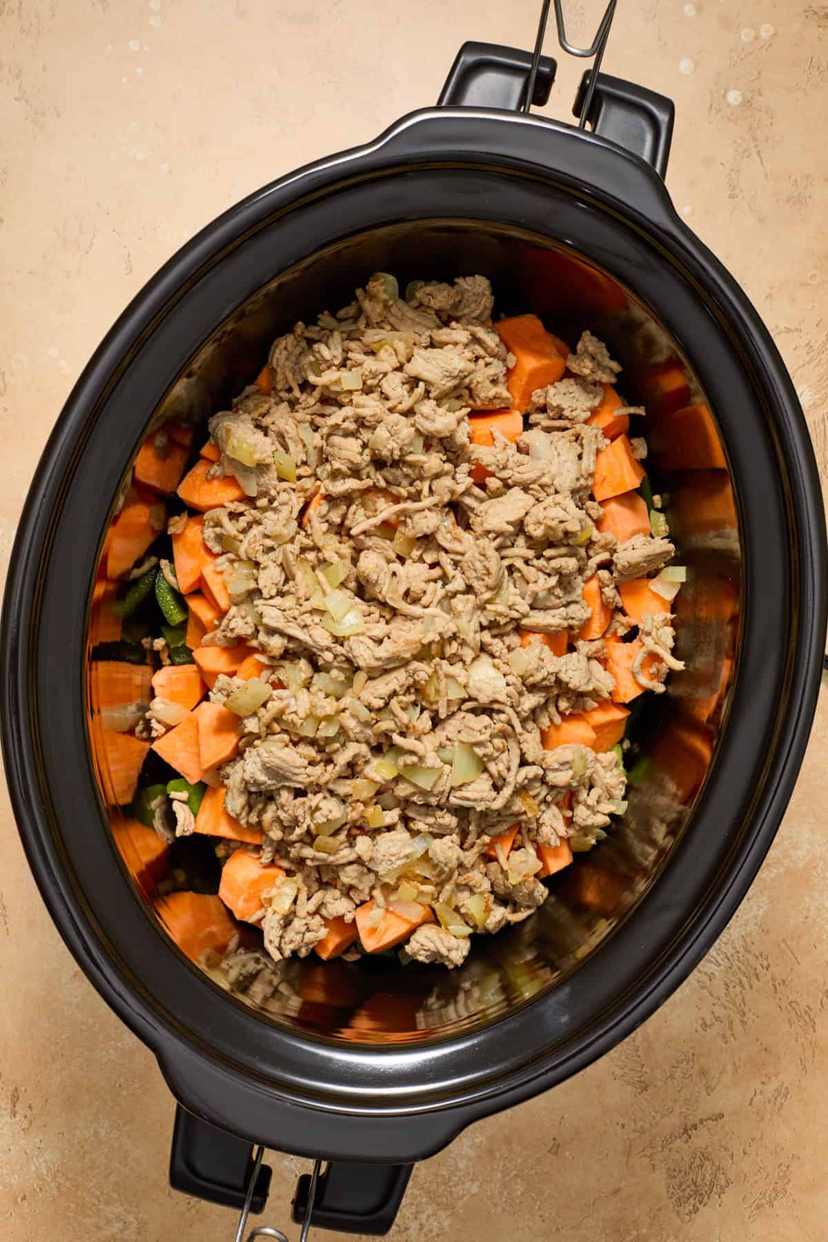 Ground turkey added to crockpot with sweet potatoes and peppers.